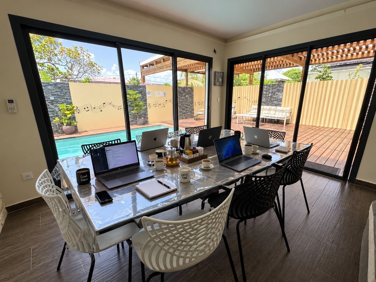 Une réunion autour de la table, les baies ouvertes sur la terrasse